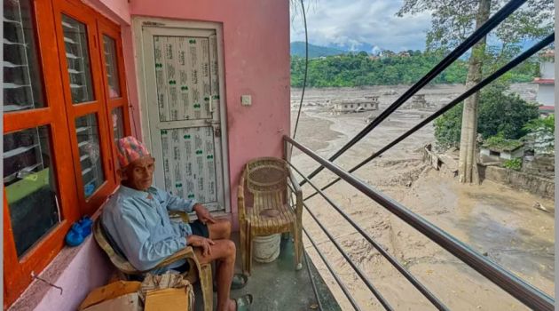 নেপালের নুয়াকোট জেলায় আকস্মিক বন্যায় তৃশূলী নদী প্লাবিত হওয়ার পর বন্যার পানি ও ধ্বংসাবশেষে ঘেরা নিজের বাড়ির ব্যালকনিতে বসে আছেন এক বাসিন্দা।
